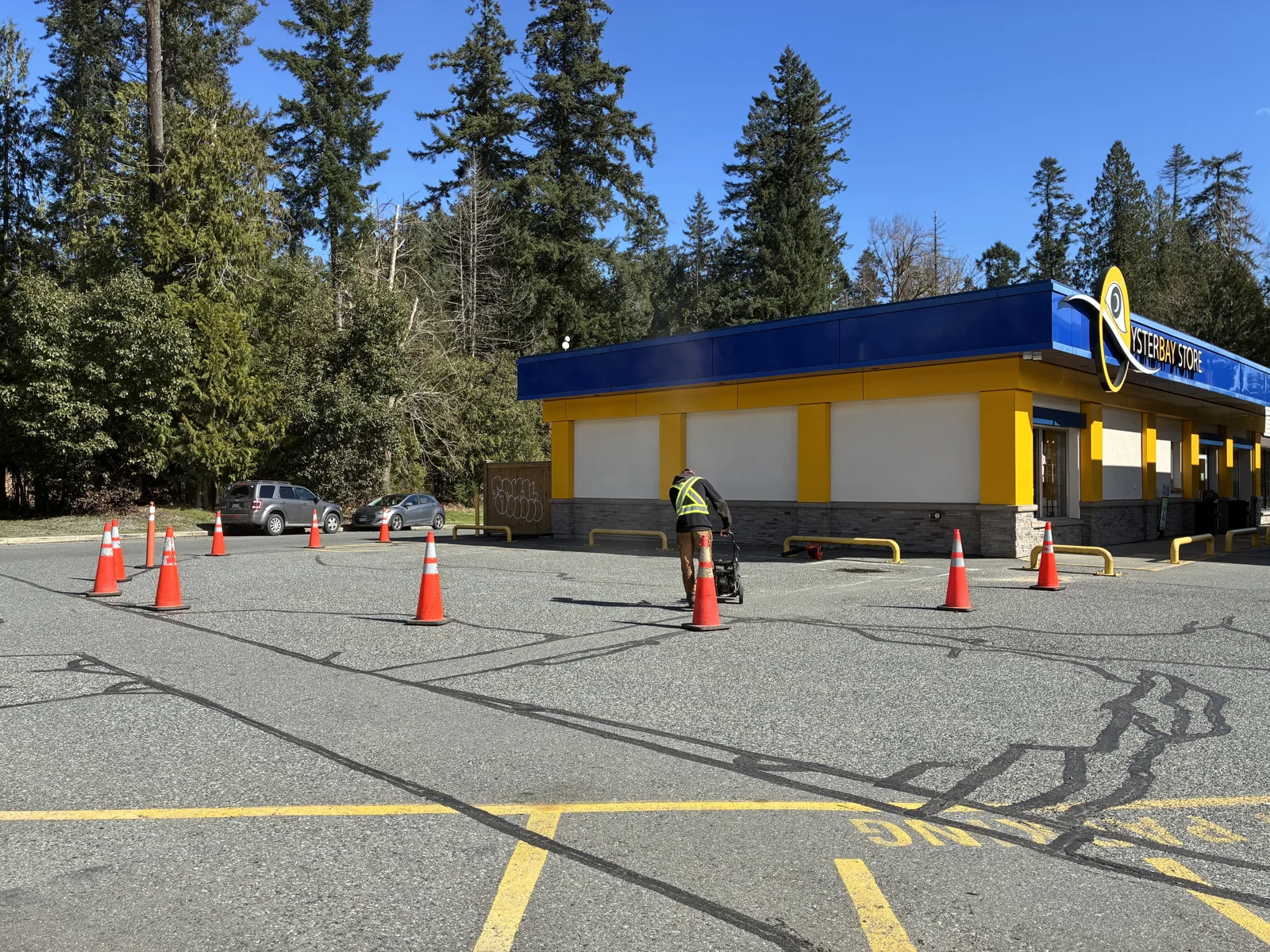 Crack sealing at Oyster Bay Chevron with cones around the work area.