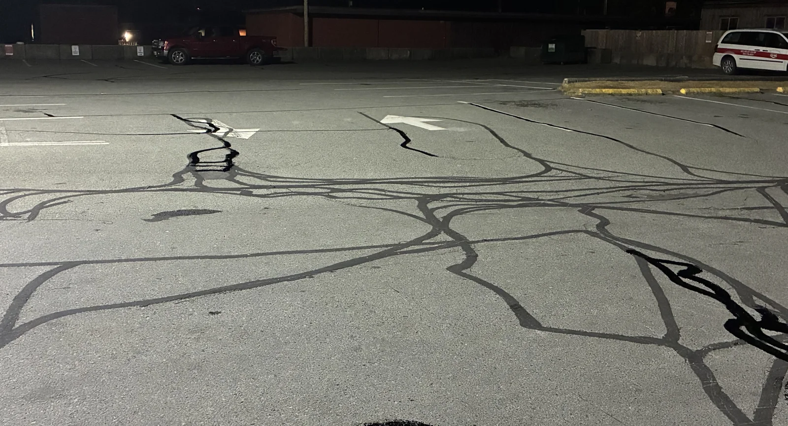 Crack sealing in the Ucluelet General Store parking lot at night.